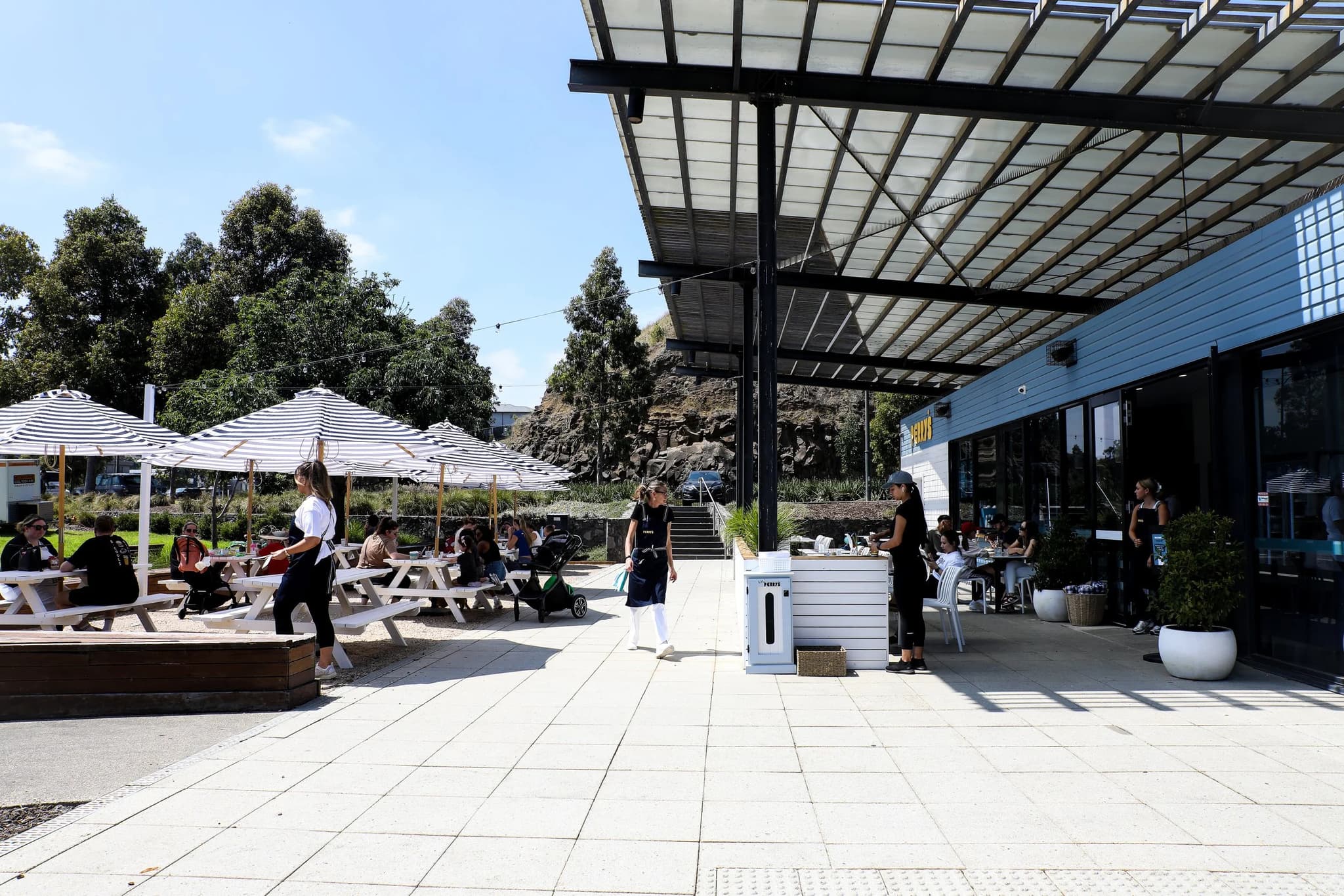 The forecourt under the pergola, people arriving